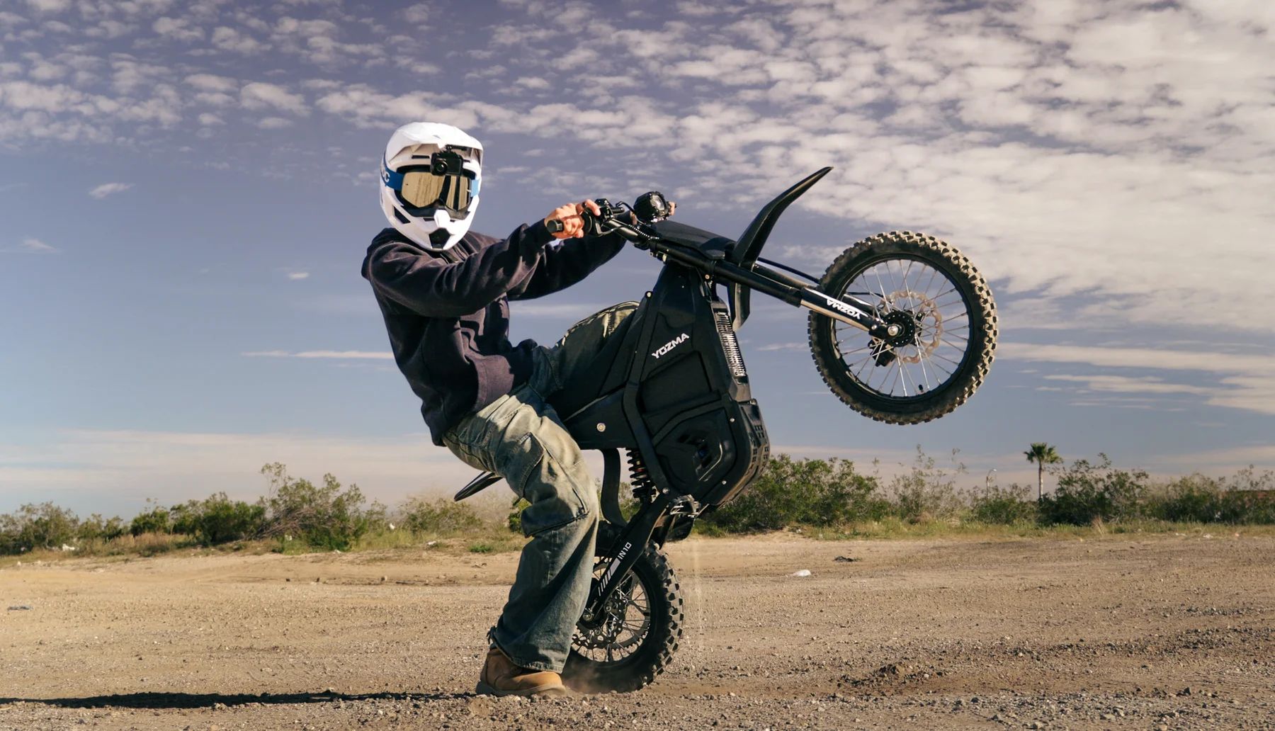 Rijder op een zwarte Yozma IN 10 elektrische pitbike op offroad-terrein